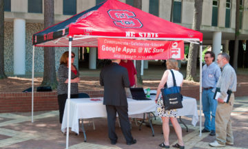 A tent from OIT is standing in the brickyard, advertising Google Apps.